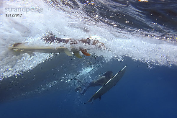 Freunde surfen unter Wasser im Meer