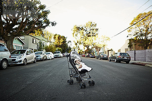 Kleiner Junge im Kinderwagen mitten auf der Strasse