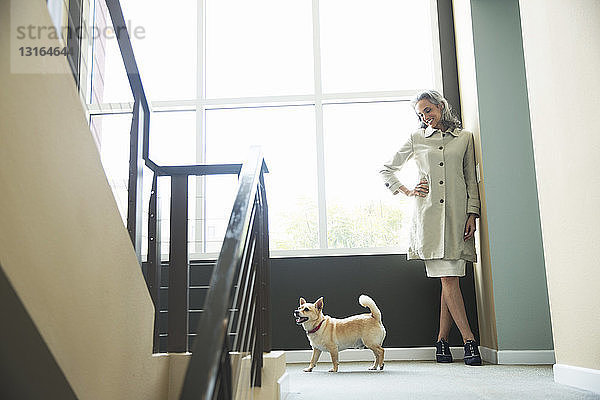 Reife Frau und Haushund auf der Treppe