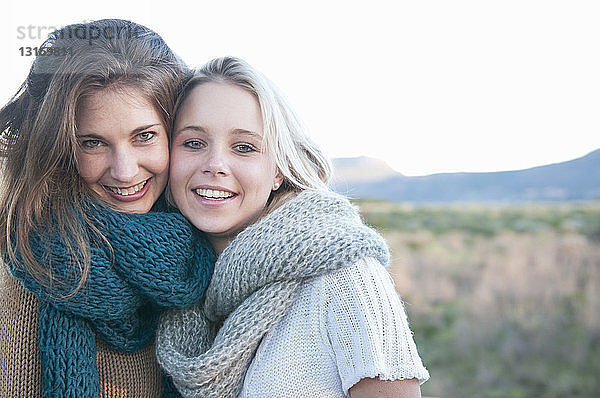 Zwei junge Frauen tragen einen gestrickten Schal