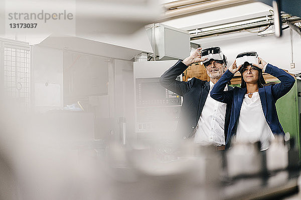 Geschäftsmann und Frau in einem High-Tech-Unternehmen mit VR-Brille