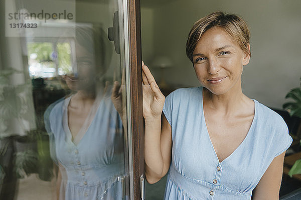 Porträt einer lächelnden Frau am französischen Fenster
