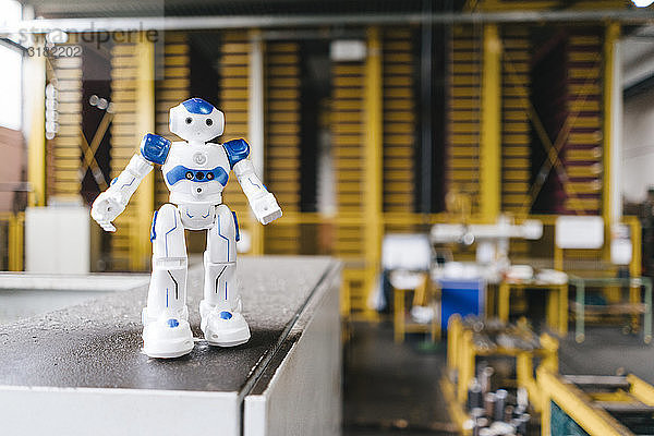 Spielzeugroboter steht auf einem Regal im Logistikzentrum