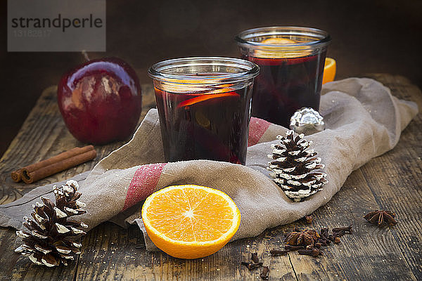 Zwei Gläser Glühwein mit Orangenscheiben zur Weihnachtszeit