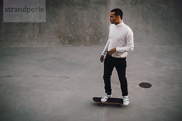 Hochwinkelaufnahme eines jungen Mannes beim Skateboarden im Park