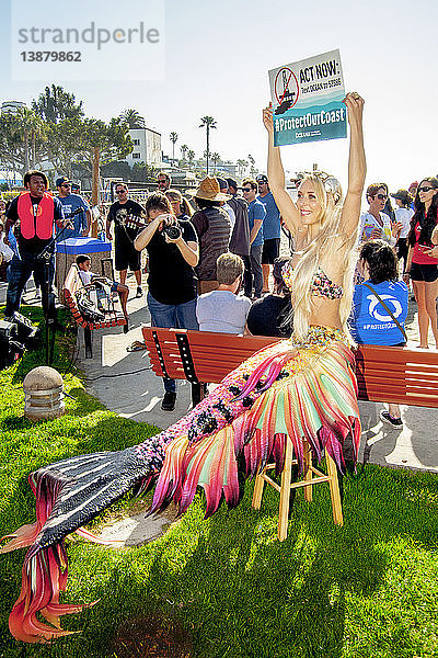 A young female demonstrator in a mermaid costume joins a demonstration opposing offshore oil drilling in Laguna Beach,  CA