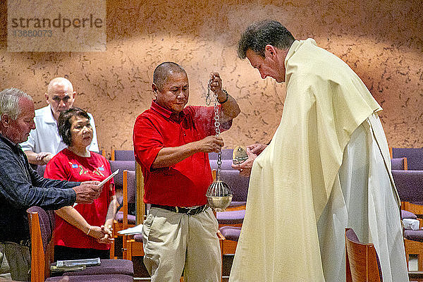 A deacon lights an incense burner at the start of a Divine Mercy and Benediction service