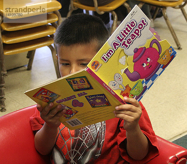 Preschool latino boy reading