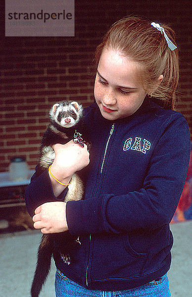 Young Girl Holding a Pet Ferret