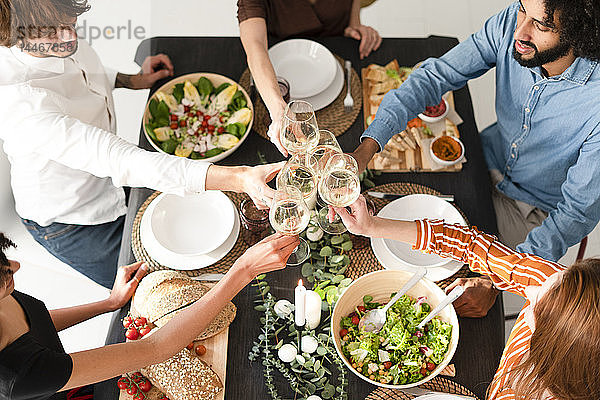 Freunde feiern eine Dinnerparty,  klirrende Gläser,  Blick von oben