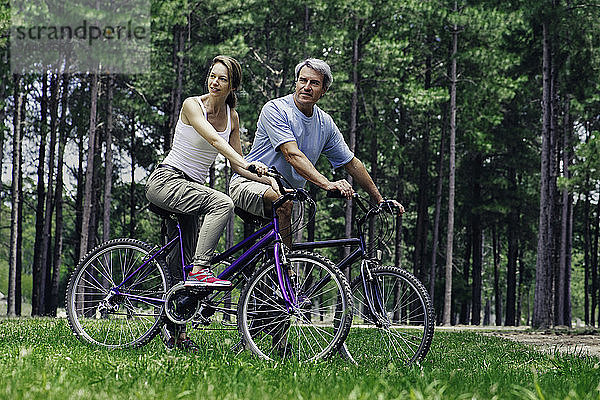 Älteres Paar mit Fahrrädern im Wald