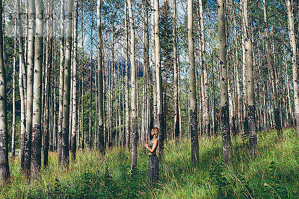 Frau macht Gebetspose im Wald,  Banff,  Kanada