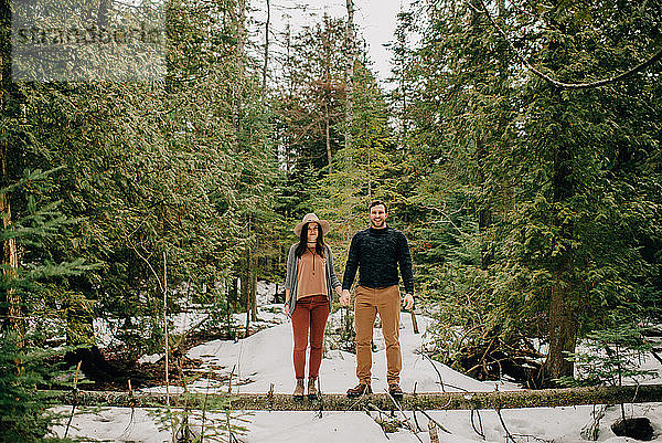 Ehepaar steht auf umgestürztem Baumstamm im Wald,  Tobermory,  Kanada