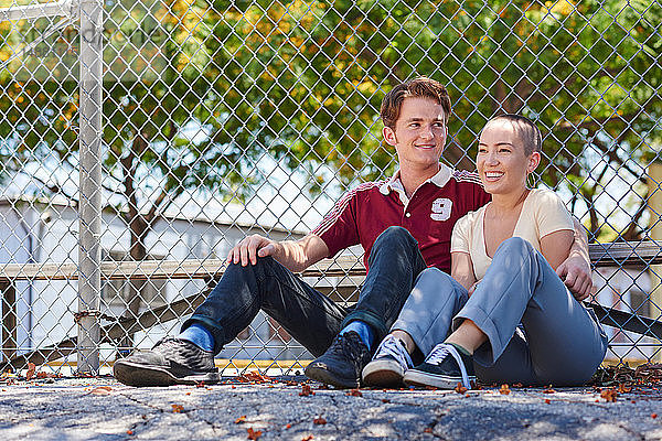 Junges Paar sitzt am Parkzaun,  Los Angeles,  Kalifornien,  USA