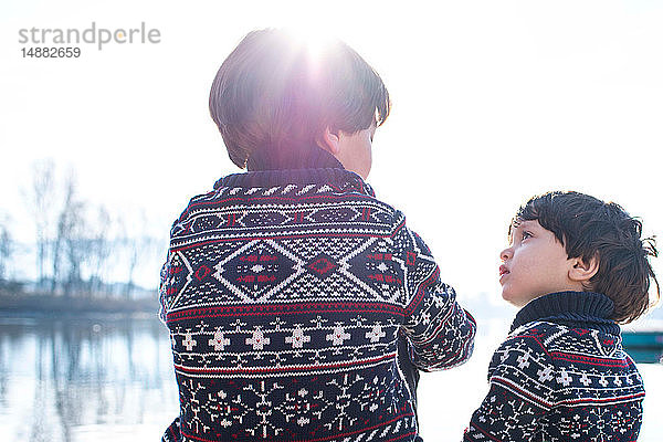 Junge und kleiner Bruder im passenden Pullover im Gespräch am Comer See,  Comer See,  Lecco,  Lombardei,  Italien