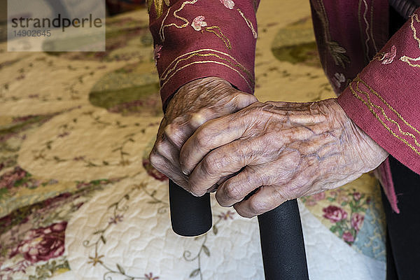 Ältere Frau hält sich mit den Händen an einem Stock fest; Olympia,  Washington,  Vereinigte Staaten von Amerika