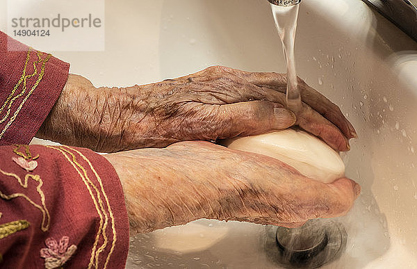 Ältere Frau wäscht sich die Hände; Olympia,  Washington,  Vereinigte Staaten von Amerika