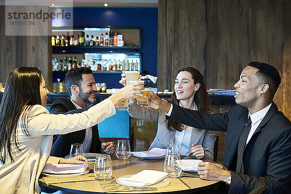 Geschäftsleute stoßen in einer Bar auf ein Getränk an
