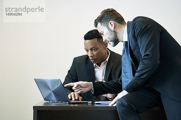 Geschäftsleute besprechen ein Projekt am Laptop