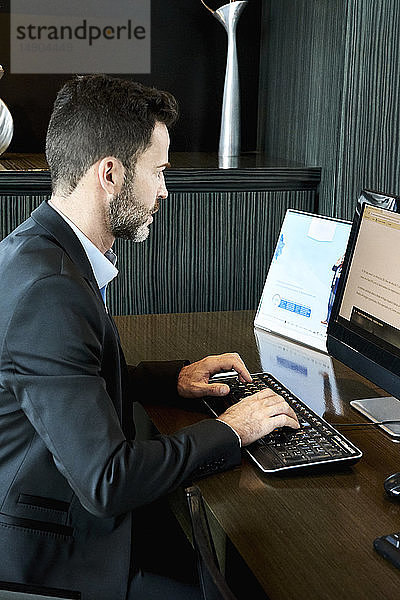 Geschäftsmann arbeitet am Computer im Hotel