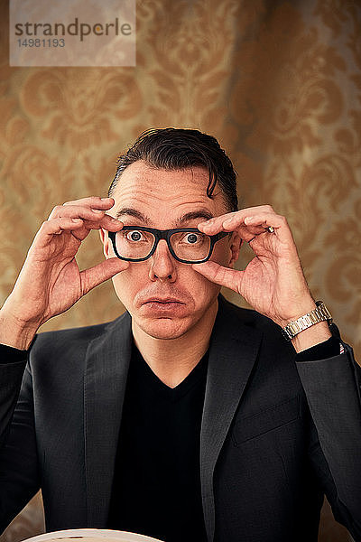 Komiker,  der eine Brille für klareres Sehen anpasst