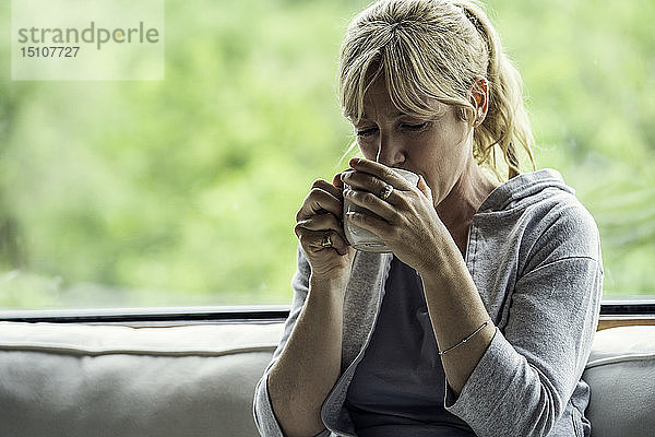 Reife Frau trinkt Kaffee zu Hause