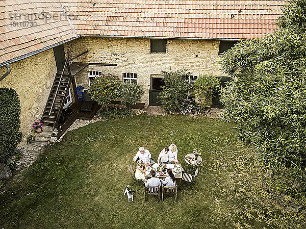 Familie isst im Sommer gemeinsam im Garten