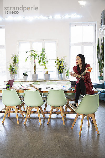 Frau am Tisch sitzend in einem modernen Büro