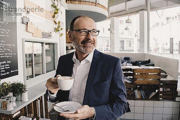 Ein reifer Geschäftsmann trinkt einen Kaffee in einem Café