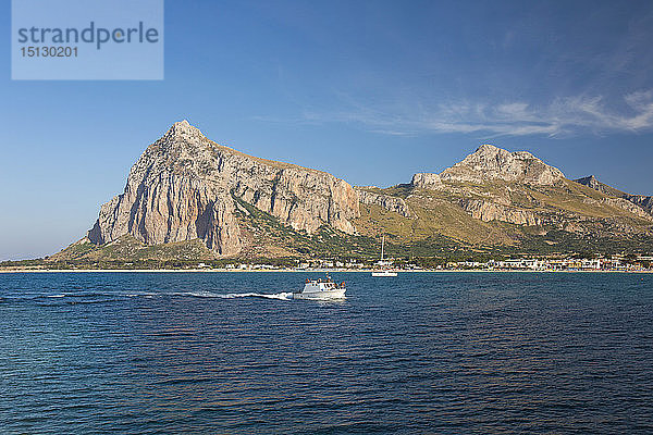 Blick über die Bucht auf den Monte Monaco und den Pizzo di Sella,  kleines Boot bei der Rückkehr in den Hafen,  San Vito Lo Capo,  Trapani,  Sizilien,  Italien,  Mittelmeer,  Europa
