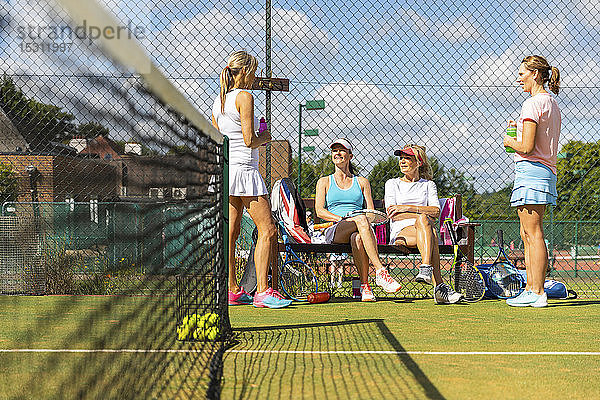Reife Frauen im Tennisclub machen eine Spielpause