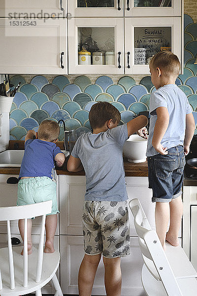 Drei Brüder kochen Pfannkuchen in der Küche