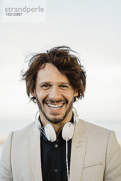 Porträt eines lachenden Geschäftsmannes mit Kopfhörer