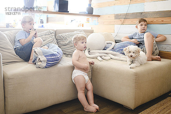 Drei kleine Brüder sehen im Wohnzimmer fern