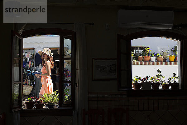 Modische junge Touristin,  die in einer Gasse spazieren geht,  von innen gesehen,  Frigiliana,  Málaga,  Spanien