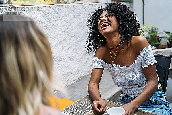 Multikulturelle Frauen lachen in einem Cafe