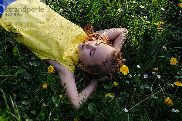 Mädchen entspannt sich auf Blumenwiese