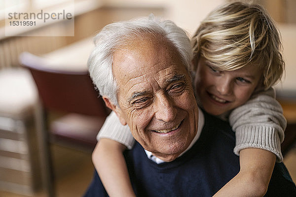 Glücklicher Enkel umarmt Großvater