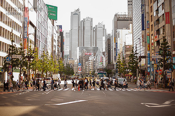Menschen,  die auf einem Fußgängerüberweg in Tokio gehen