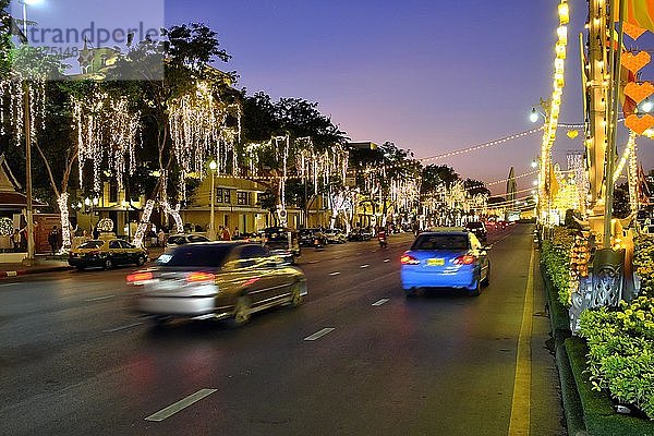Beleuchtete,  mit Lichtern geschmückte Straße mit Autoverkehr in der Abenddämmerung,  Rachadamnoen Klang Road,  Bangkok,  Thailand,  Asien