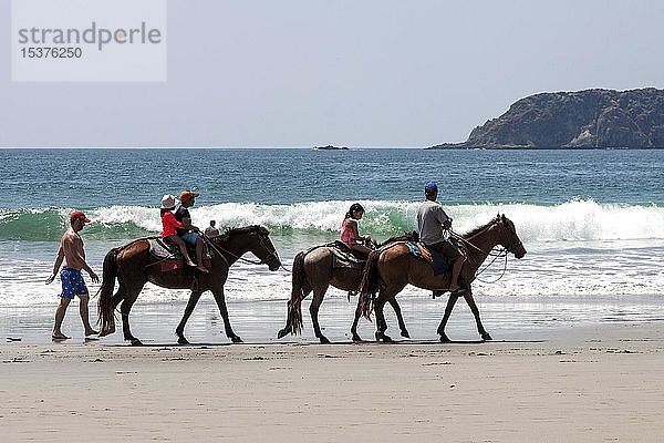 Reiter auf dem Pferderücken am Strand Playa Espadilla,  Nationalpark Manuel Antonio,  Provinz Puntarenas,  Costa Rica,  Mittelamerika