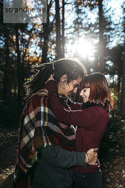 Glückliches junges verliebtes Paar im Wald