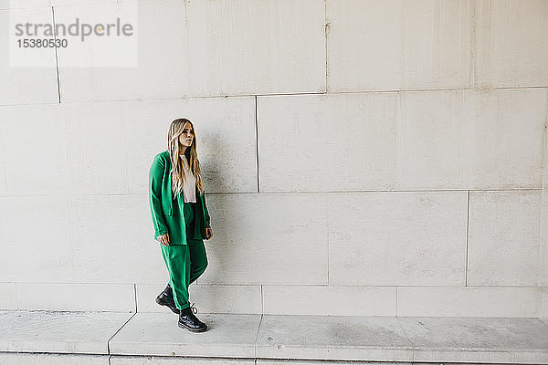 Blonde junge Frau im grünen Hosenanzug im Freien