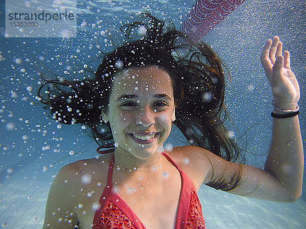 Unterwasserporträt eines lächelnden Mädchens