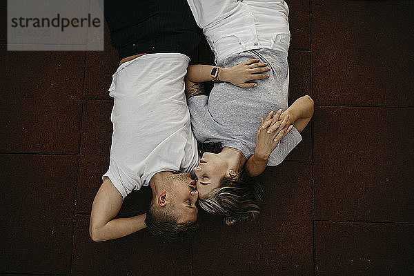 Auf dem Boden liegendes junges Paar,  von oben