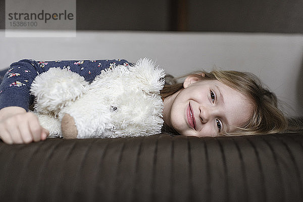 Porträt eines glücklichen kleinen Mädchens mit weißem Teddybär