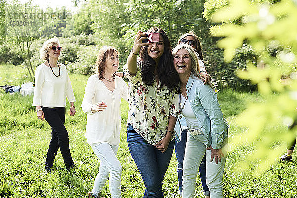 Gruppe glücklicher Frauen,  die im Park ein Selfie machen