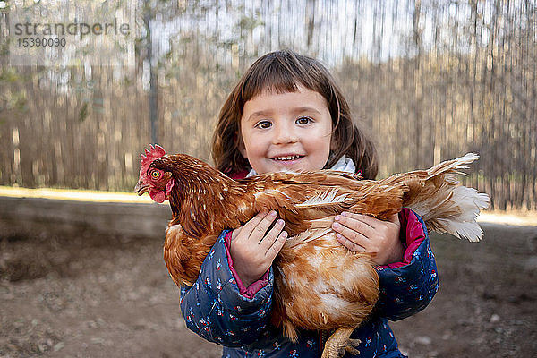 Porträt eines glücklichen Kleinkindes mit Huhn