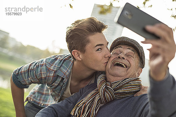 Glücklicher älterer Mann,  der mit seinem Enkel ein Selfie macht