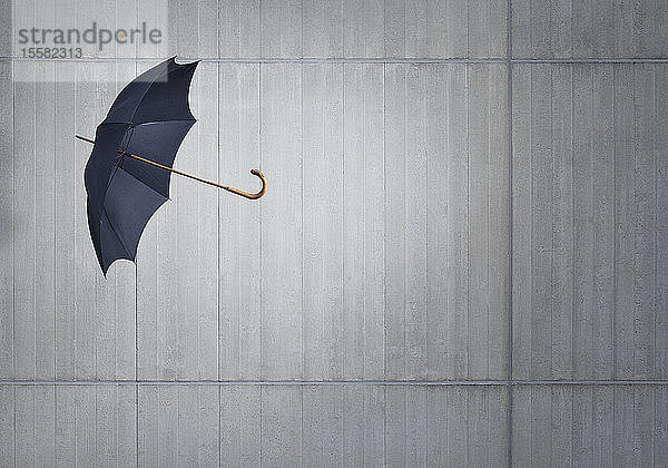 Schwarzer fliegender Regenschirm